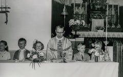 OVI-00001321 kinderen met pastoor in RKkerk tijdens eerstcommuniefeest